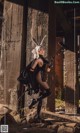 A woman dressed as a bunny holding a gun.