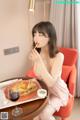 A woman sitting at a table eating a sandwich and french fries.