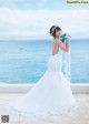 A woman in a wedding dress holding a bouquet of flowers.